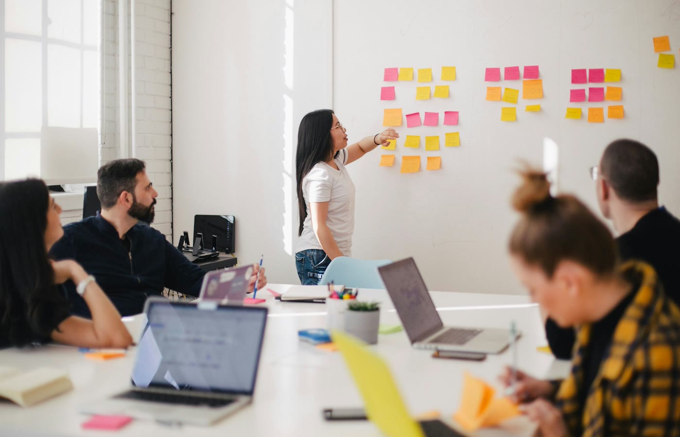 Founders planning product scope and cutting a feature list on a whiteboard